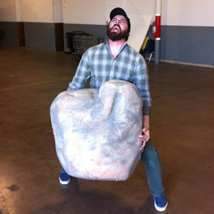 Director Jason Whitbeck lifts an enormous boulder